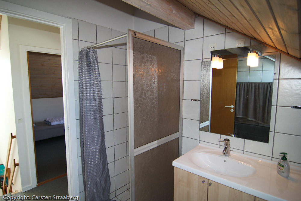 Badeværelse med vask, spejl brusekabine. 